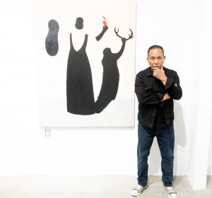 Photo of Chicano painter Gronk in front of one of his 'Tormenta' paintings at Cerritos College. Photo by Keith Walsh